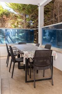 a table and chairs on a patio with windows at Stunning Sea View Cosy Apartment in Gundogan