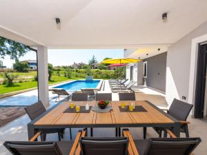 a patio with a table and chairs and a pool at Holiday Home Vala by Interhome in Vodnjan