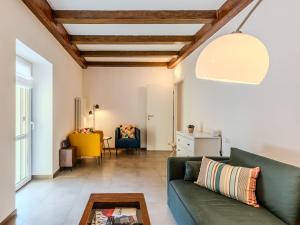 a living room with a green couch and a table at Apartment Tre Laghi by Interhome in Carlazzo