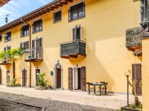 a yellow building with a table in front of it at Apartment Tre Laghi by Interhome in Carlazzo