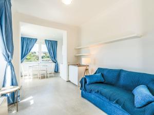 Una sala de estar con un sofá azul y una mesa. en Apartment Nausicaa by Interhome, en Arma di Taggia
