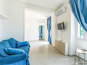 Una sala de estar con un sofá azul y un televisor. en Apartment Nausicaa by Interhome, en Arma di Taggia 24 fotos más