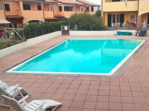 ein Pool mit zwei Liegestühlen daneben in der Unterkunft Apartment Mara by Interhome in Badesi