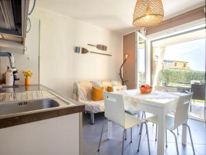 eine Küche und ein Esszimmer mit einem weißen Tisch und Stühlen in der Unterkunft Apartment Mara by Interhome in Badesi