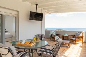 a dining room with a table and chairs and the ocean at Villa Alia in Archangelos