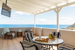 a balcony with a table and chairs and the ocean at Villa Alia in Archangelos