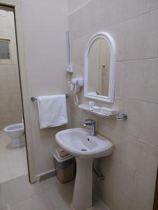 a bathroom with a sink and a mirror and a toilet at العييري للشقق المخدومة النعيرية 1 in Al Nairyah +5 photos