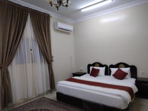 a bedroom with a large bed and a window at العييري للشقق المخدومة النعيرية 1 in Al Nairyah