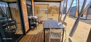 a wooden deck with a table and chairs on it at Sak Mobile Home Pirovac III in Pirovac