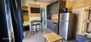 a small kitchen with a refrigerator and a table at Sak Mobile Home Pirovac III in Pirovac