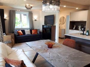 a living room with a table and a kitchen at Schafberg Luxury Apartment in St. Wolfgang