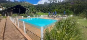 a swimming pool in a resort with mountains in the background at Casa de Campo em Teresópolis in Teresópolis