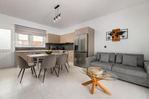 a kitchen and living room with a couch and a table at Villa Alia in Archangelos +24 photos