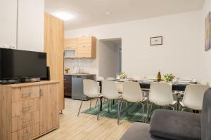 a kitchen and a dining room with a table and chairs at Esprit Apartmanház in Szajol