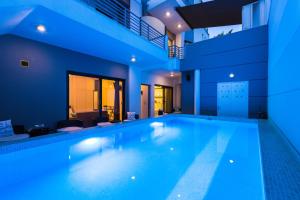 a swimming pool in a house with blue lighting at Rethymno Hills Apartments in Rethymno