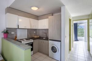 a kitchen with white cabinets and a washer and dryer at Akrotiri apartment in Pefkochori +23 photos