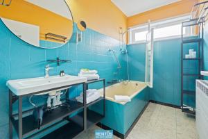 a blue bathroom with a sink and a tub at Yde et Maré - single level home with garden in Middelkerke +12 photos