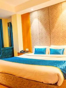 ein Schlafzimmer mit einem großen Bett mit blauen Kissen in der Unterkunft Alarks Inn in Shimla