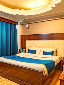 ein Schlafzimmer mit einem großen Bett mit blauer Bettwäsche in der Unterkunft Alarks Inn in Shimla + 1 Foto