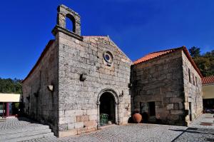 an old building with a clock on the front of it at Pousada Convento de Belmonte in Belmonte