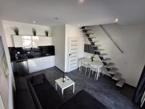 a living room with a couch and a staircase at Domki Black Pearl Mielno basen sauna jacuzzi in Mielno
