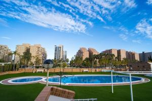 a swimming pool in a park with buildings in the background at Apartamento en Magic World in Oropesa del Mar