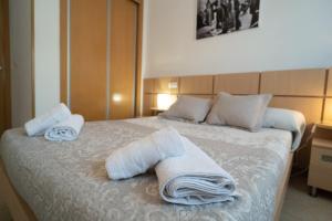 a bedroom with a bed with towels on it at Apartamento en Magic World in Oropesa del Mar +13 photos