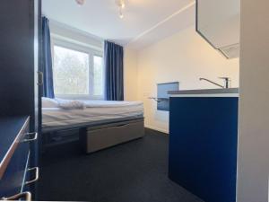 a small room with a bed and a sink at Allihoop Ängby Aces in Stockholm
