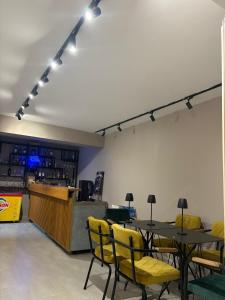 a restaurant with tables and yellow chairs and a counter at Atlantid Hospitality Hotel in Qeparo