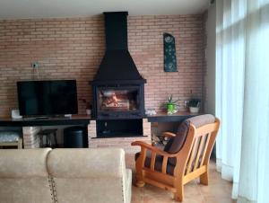 a living room with a fireplace and a couch at Ca l'Artigalas in Cardona