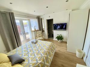 a bedroom with a bed and a tv in it at Heathrow Airport Accommodation in Staines