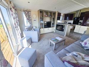 a living room with a blue couch and a table at Sea views at Serenity! in Truro
