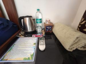 a table with a remote control on top of it at Anandi Villa Homestay in Adi