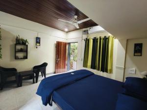 a bedroom with a blue bed and a desk at Anandi Villa Homestay in Adi