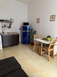 una cucina con un tavolo e un frigorifero blu di Interno 2 Il giardino segreto CENTRO a Bari