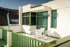 a balcony with white chairs and a table on it at Apartamentos Halley in Puerto Rico de Gran Canaria
