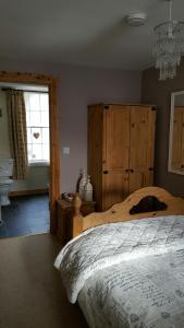 1 dormitorio con cama y lámpara de araña en The Castle Apartment en Strangford