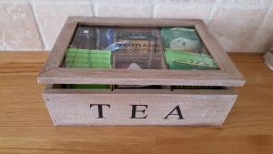 a wooden box with the word tea sitting on a table at The Castle Apartment in Strangford