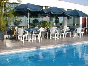 a group of chairs and tables next to a swimming pool at Hotel Boulevard in Lima