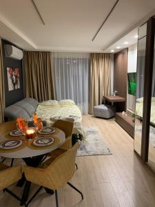 a room with a bed and a table and chairs at The Modern Nest Apartment with FREE Underground Parking in Plovdiv