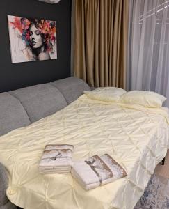 a bed with two towels on top of it at The Modern Nest Apartment with FREE Underground Parking in Plovdiv