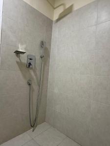 eine Dusche mit einem Schlauch in einem Badezimmer in der Unterkunft DownTown Apartments Gulberg in Lahore