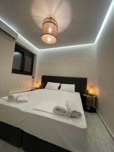 a bedroom with a white bed with towels on it at MVM rooms 5 in Nydri