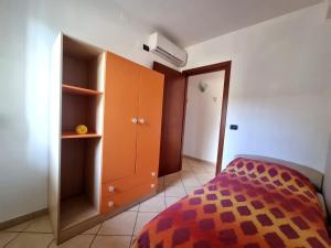 a bedroom with an orange cabinet and a bed at Holiday House ARAGONA in Cupello