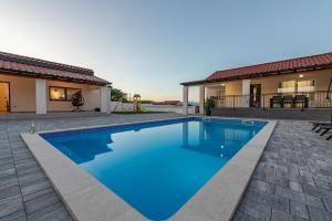 a swimming pool in the backyard of a house at Villa Chivas ZadarVillas in Donje Raštane