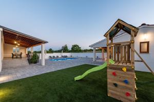 a house with a playground with a slide at Villa Chivas ZadarVillas in Donje Raštane