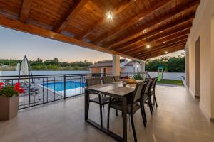 a patio with a table and chairs and a swimming pool at Villa Chivas ZadarVillas in Donje Raštane