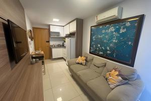 un salon avec un canapé et une grande peinture murale dans l'établissement Apt de Luxo II no Shopping DF Plaza Aguas Claras, à Brasilia