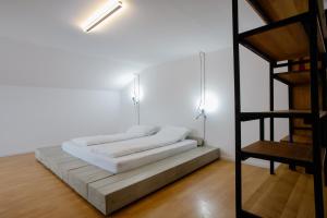 a white room with a bed and a ladder at MOBstar in Alba Iulia