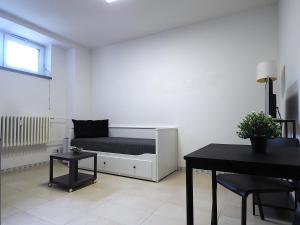 a white room with a bed and a table at Apartmán u Nové Karoliny in Slezská Ostrava